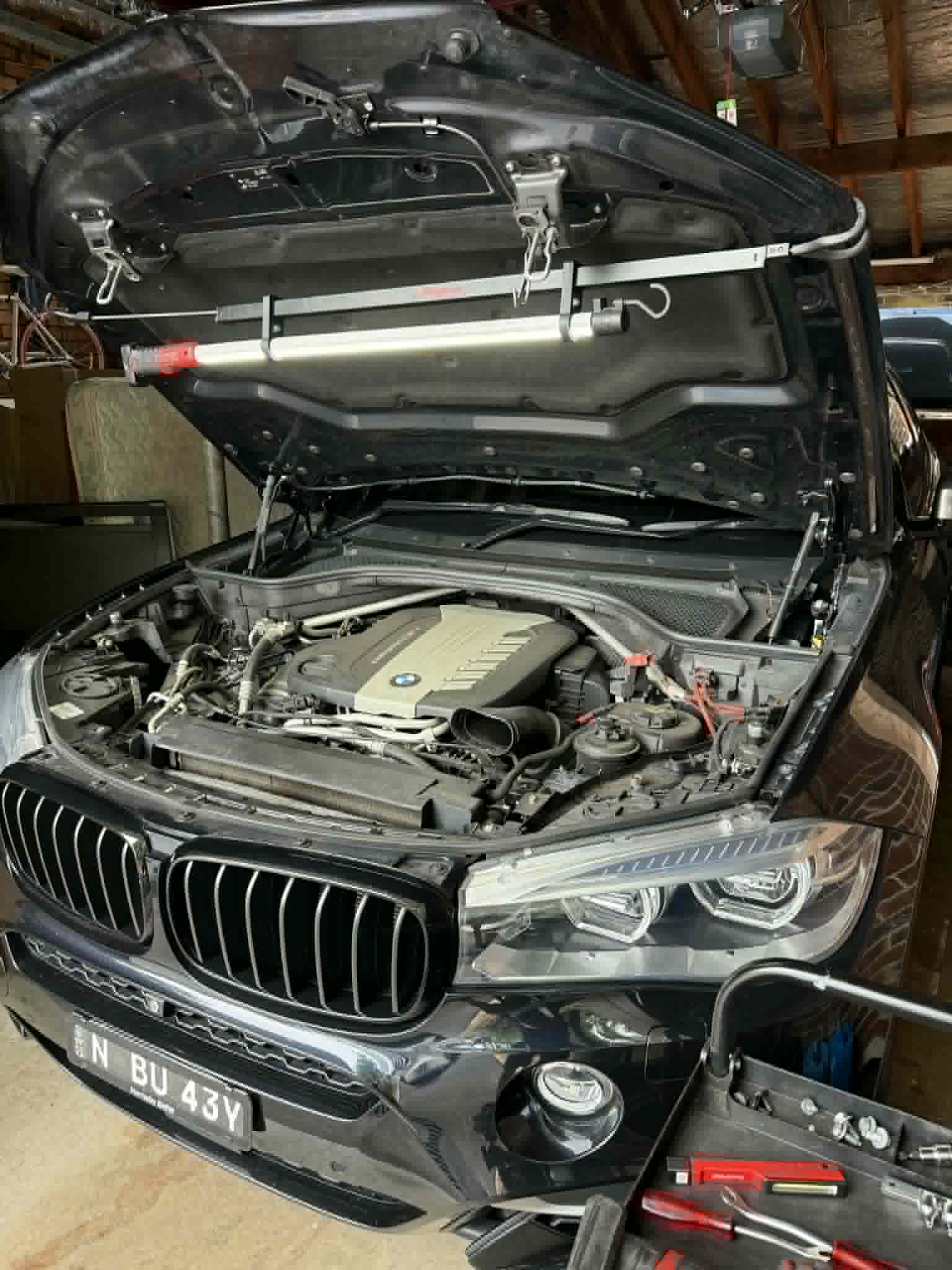 BMW X5 engine bay open for service and inspection by On The Go Garage mobile mechanic